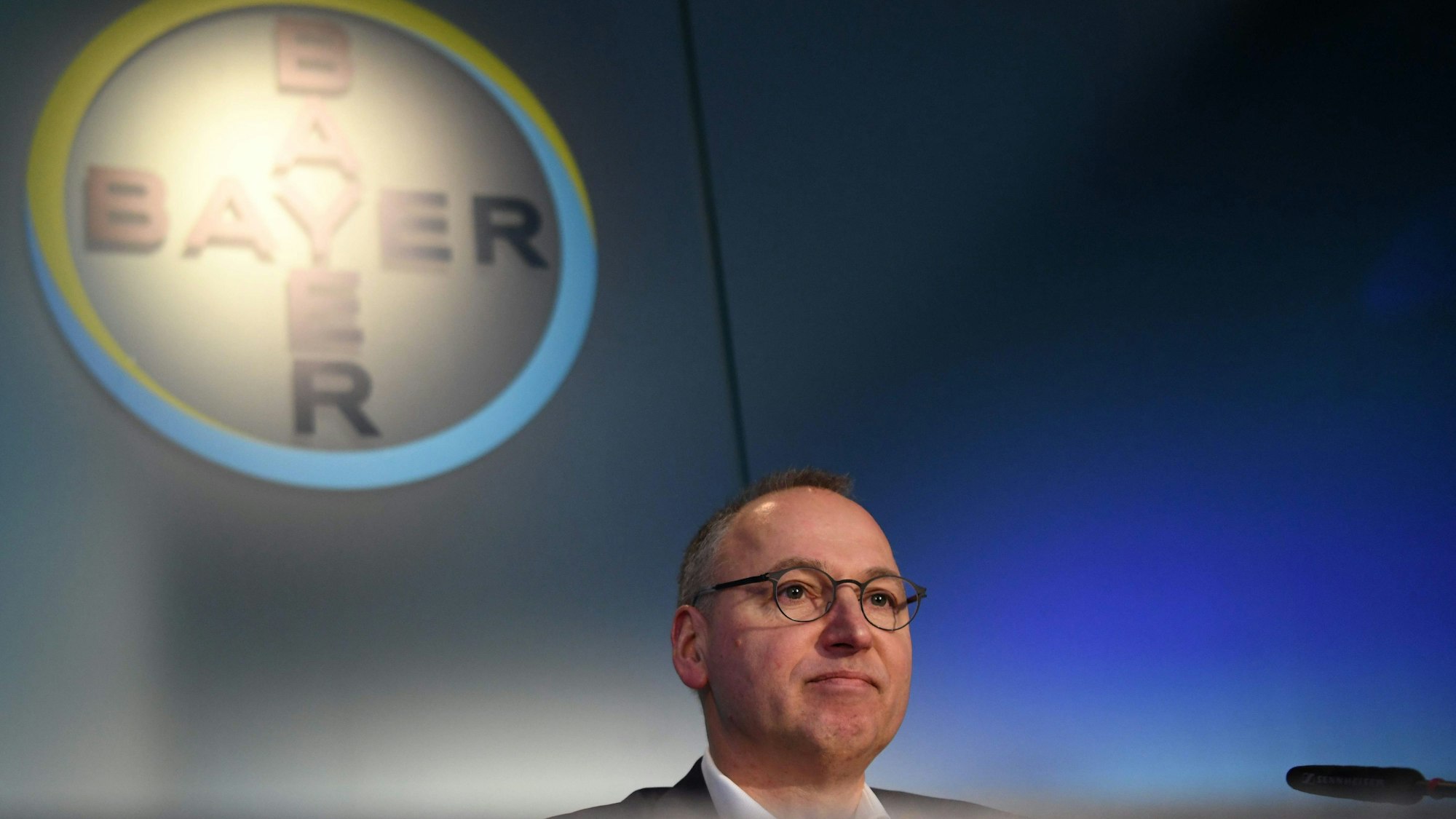Werner Baumann vor einem Bayer-Logo