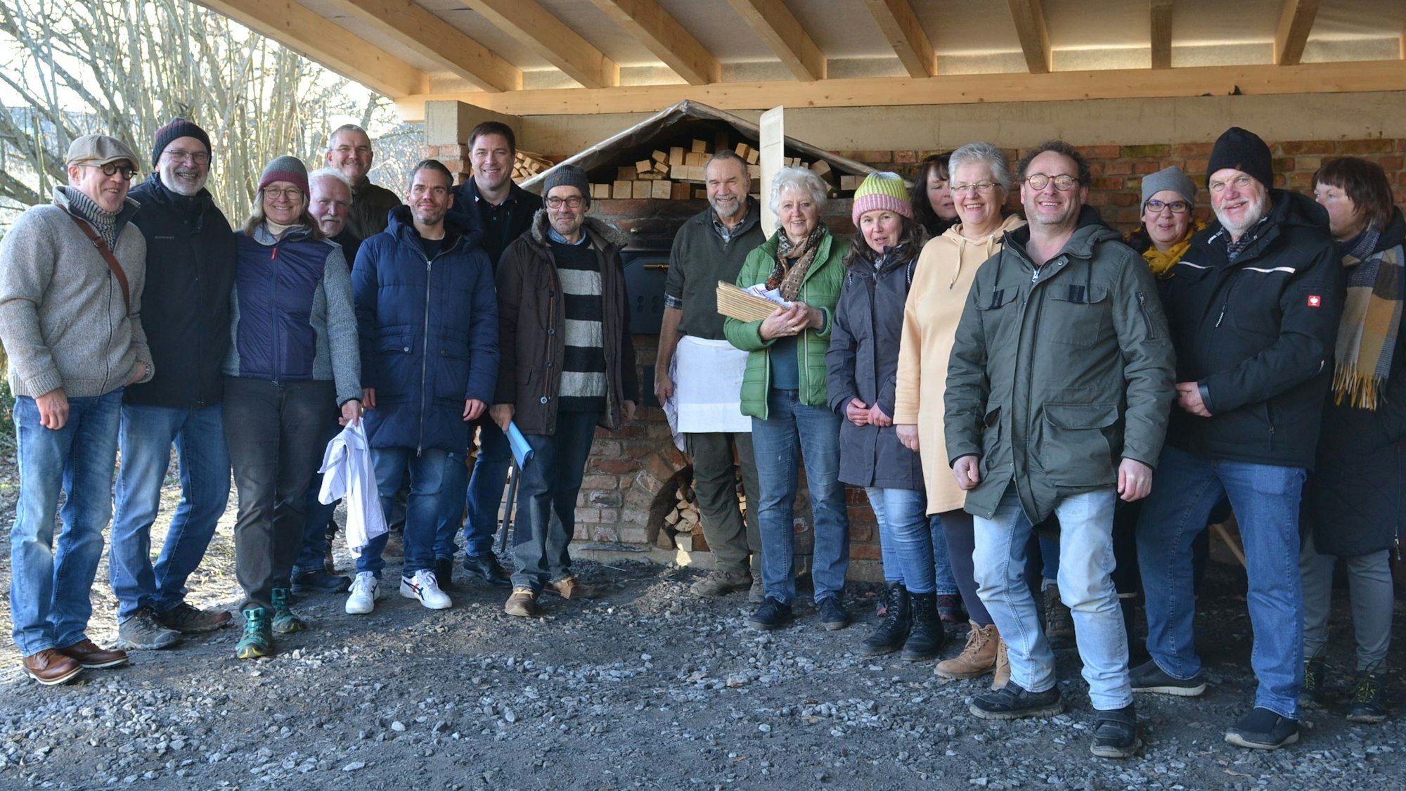 Menschen stehen vor einem Steinofen.