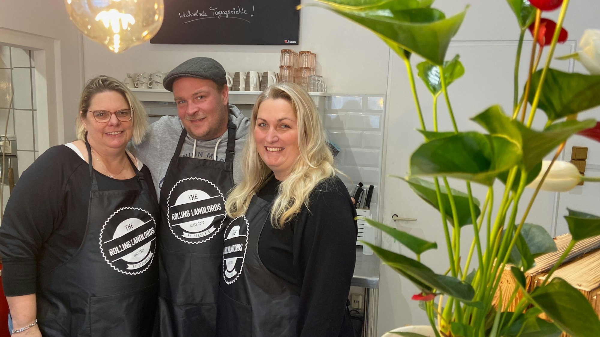 Auf dem Bild sind die Ladeninhaber und die Mitarbeiterin des Bistro „The Rolling Landlords“ in Königsdorf zu sehen.