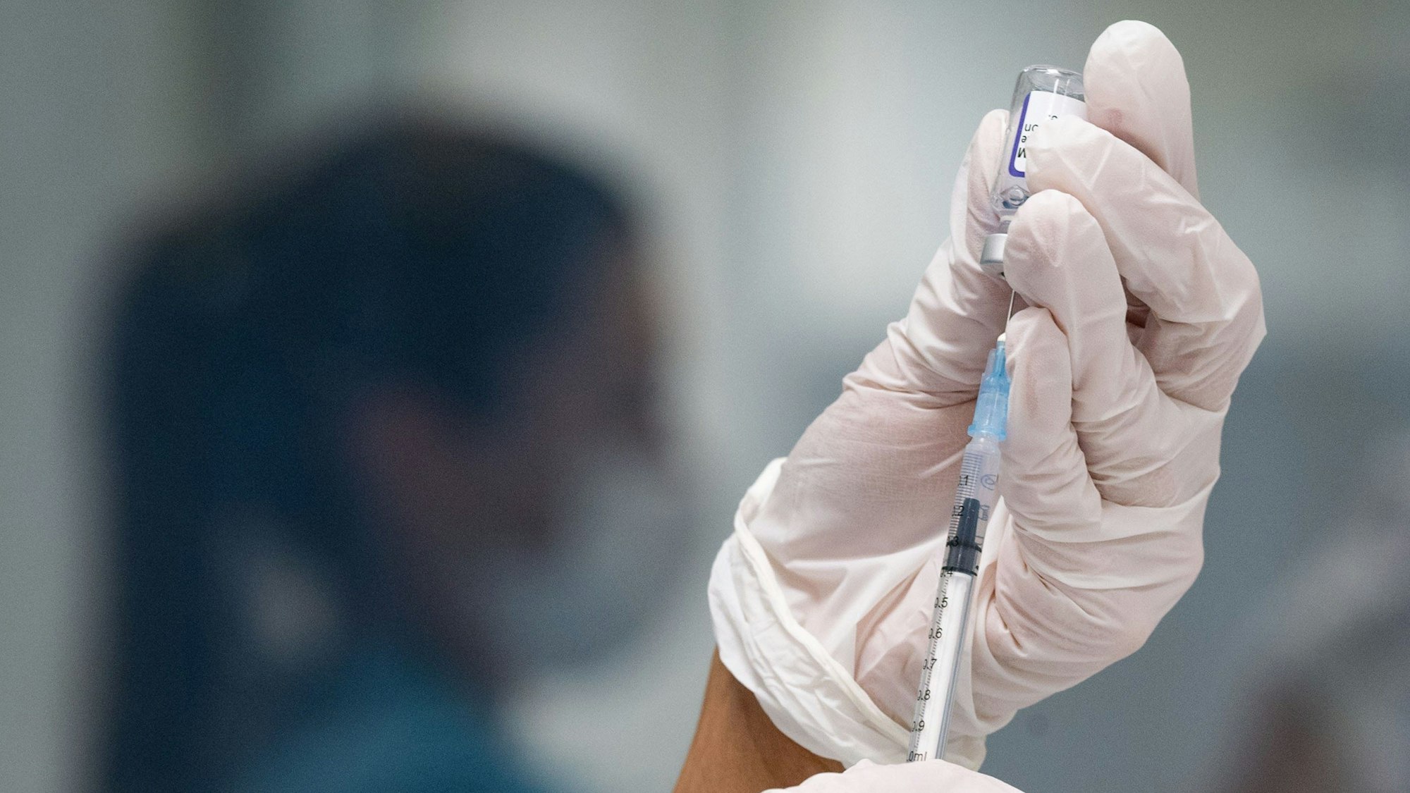 Eine Frau zieht eine Dosis des Impfstoffes von Biontech/Pfizer für eine Corona-Impfung auf.