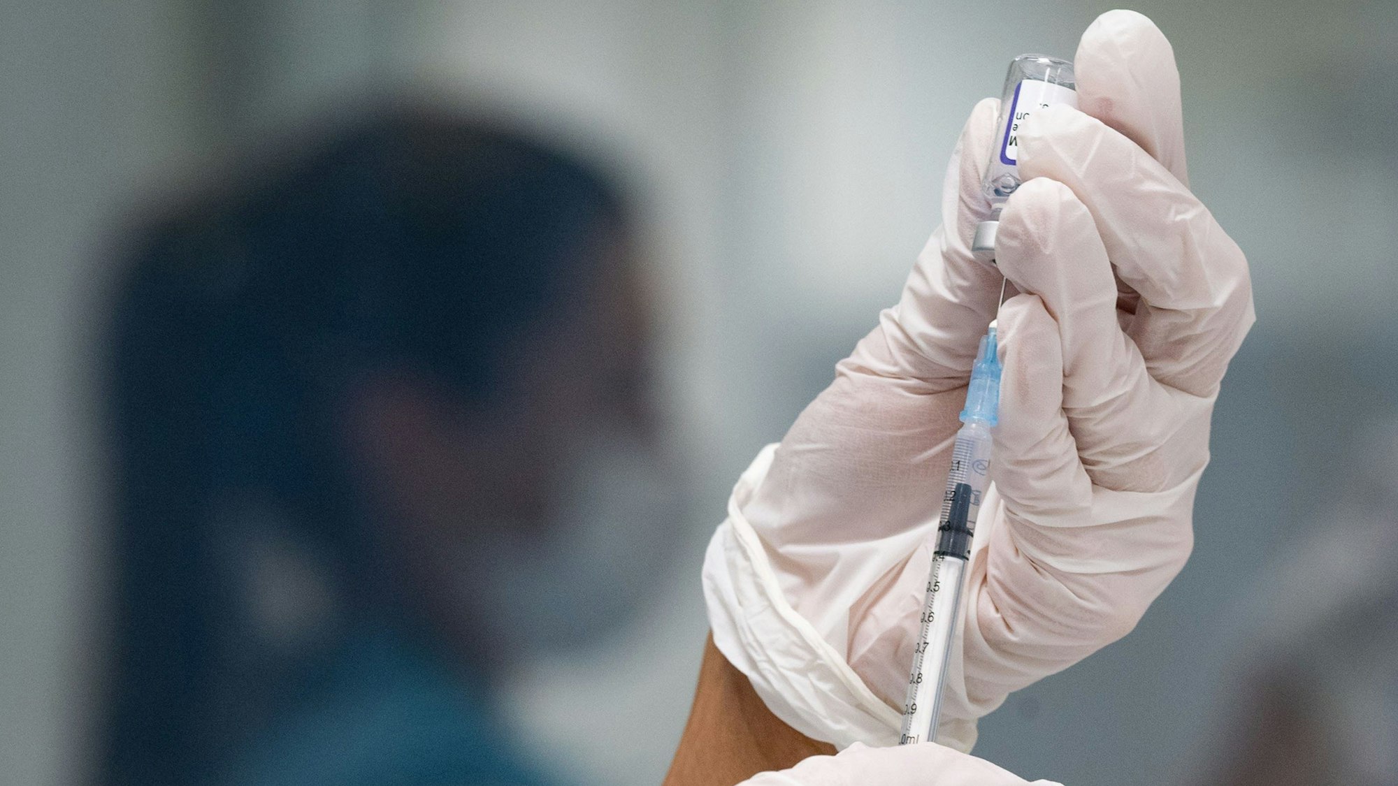 Eine Frau zieht eine Dosis des Impfstoffes von Biontech/Pfizer für eine Corona-Impfung auf.