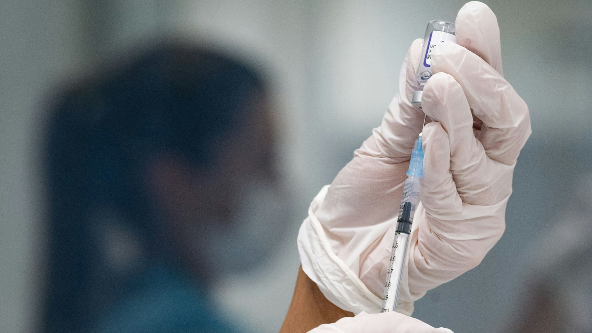 Eine Frau zieht eine Dosis des Impfstoffes von Biontech/Pfizer für eine Corona-Impfung auf.