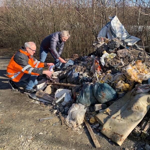 Eine ganze Wagenladung voller Bauschutt kombiniert mit Hausmüll liegt auf der Straße.