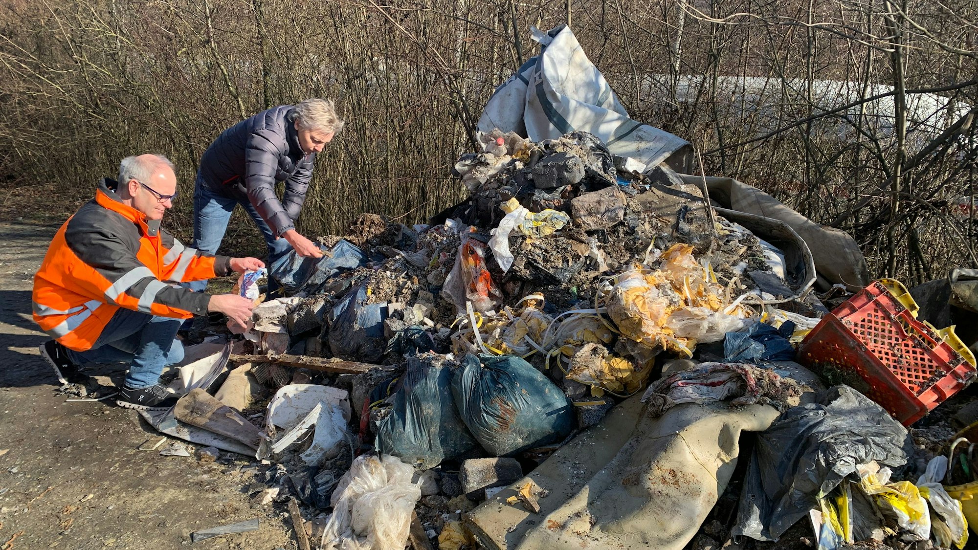 Eine ganze Wagenladung voller Bauschutt kombiniert mit Hausmüll liegt auf der Straße.