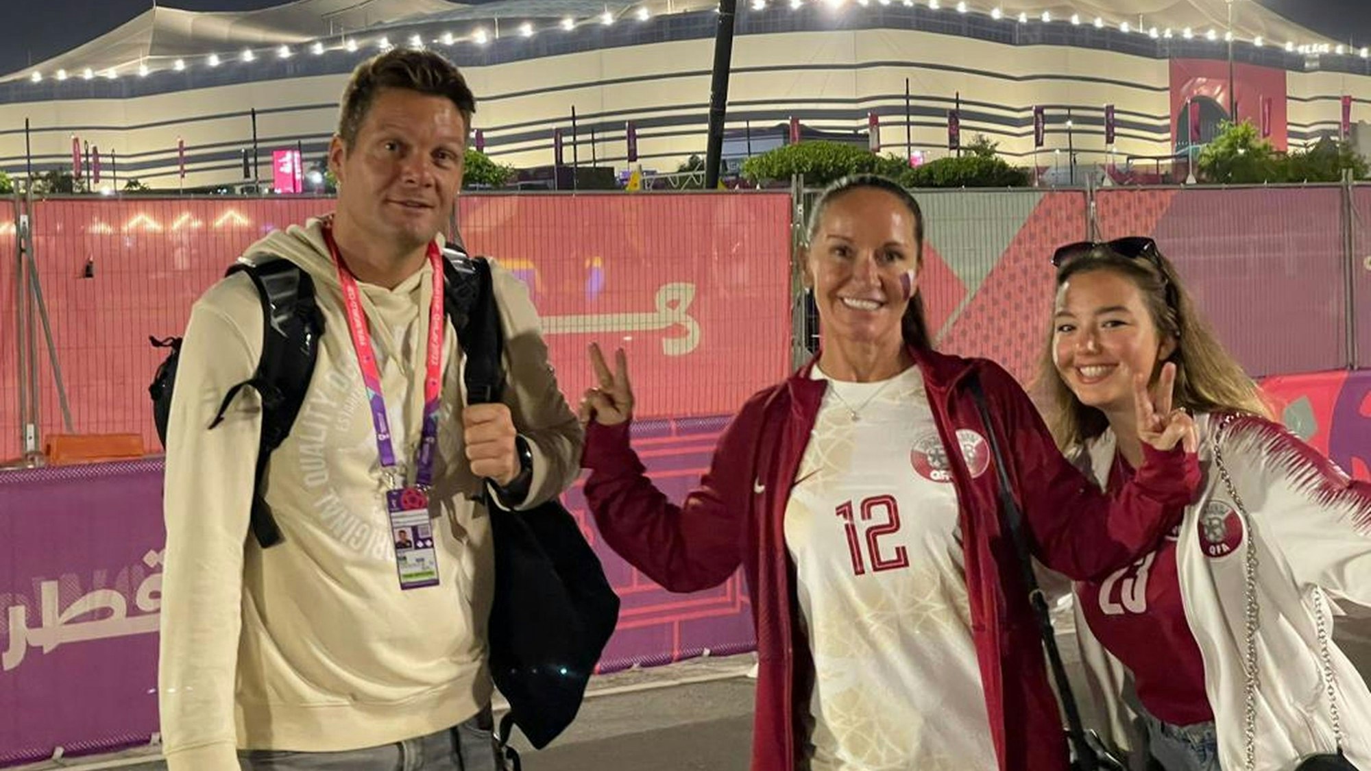 Julius Büscher und Familie stehen gemeinsam vor einem beleuchteten Stadion.