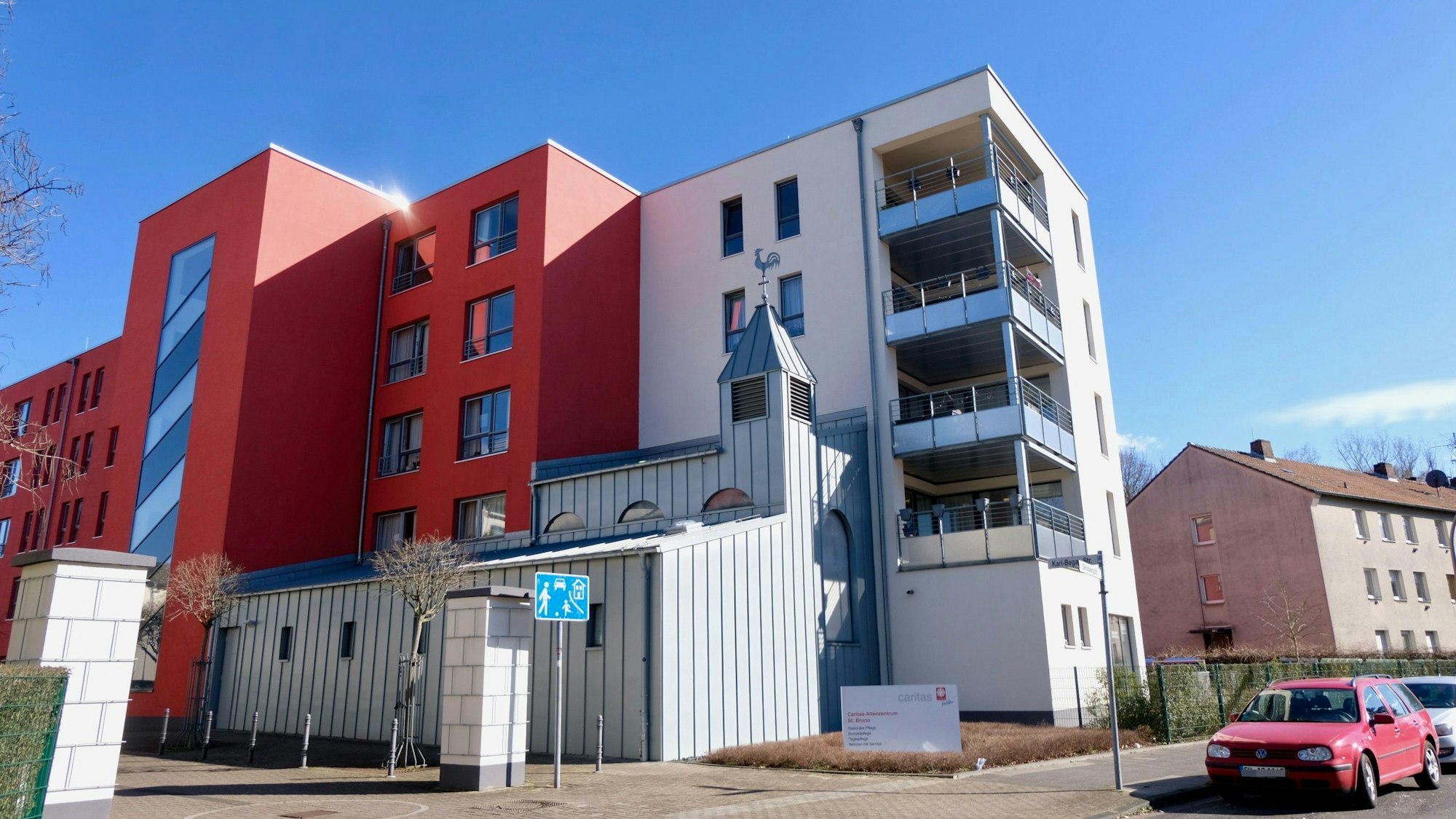 Ein rot-weißes Haus steht an einer Straße.