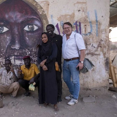 Hans Mörtter (r.) und Hassan Magdi (l.) mit anderen in Khartum vor einem Wandbild, das die 2012 erschossene Parlamentarierin Awasia Ajbna zeigt.