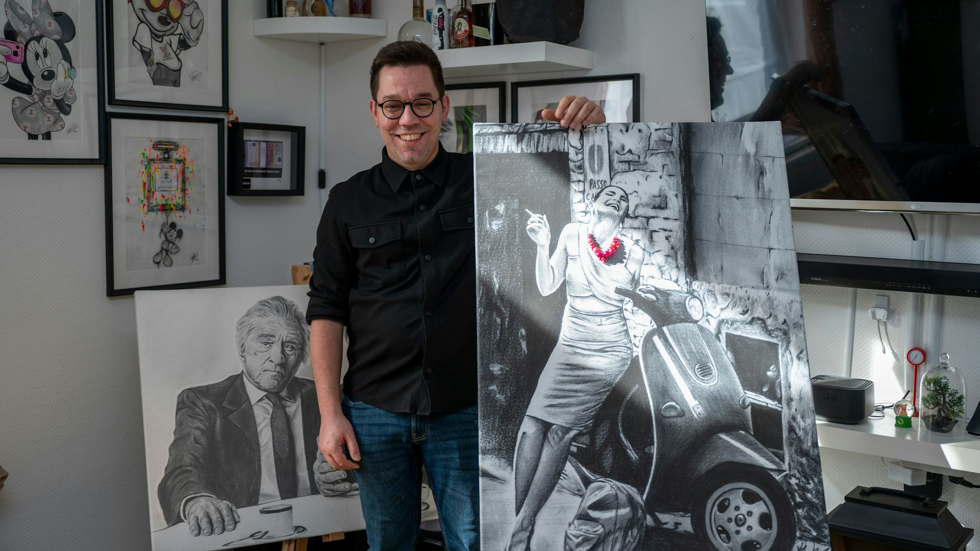 Fabio Dal Pos steht bei sich zuhause neben einer Staffelei mit einem seiner Bilder.