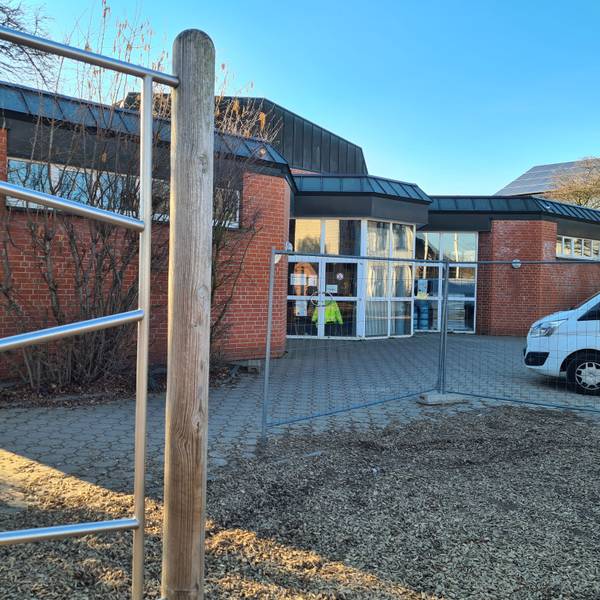Blick auf die Halle an der Ulrichschule in Sindorf, vorne steht ein Bauzaun.