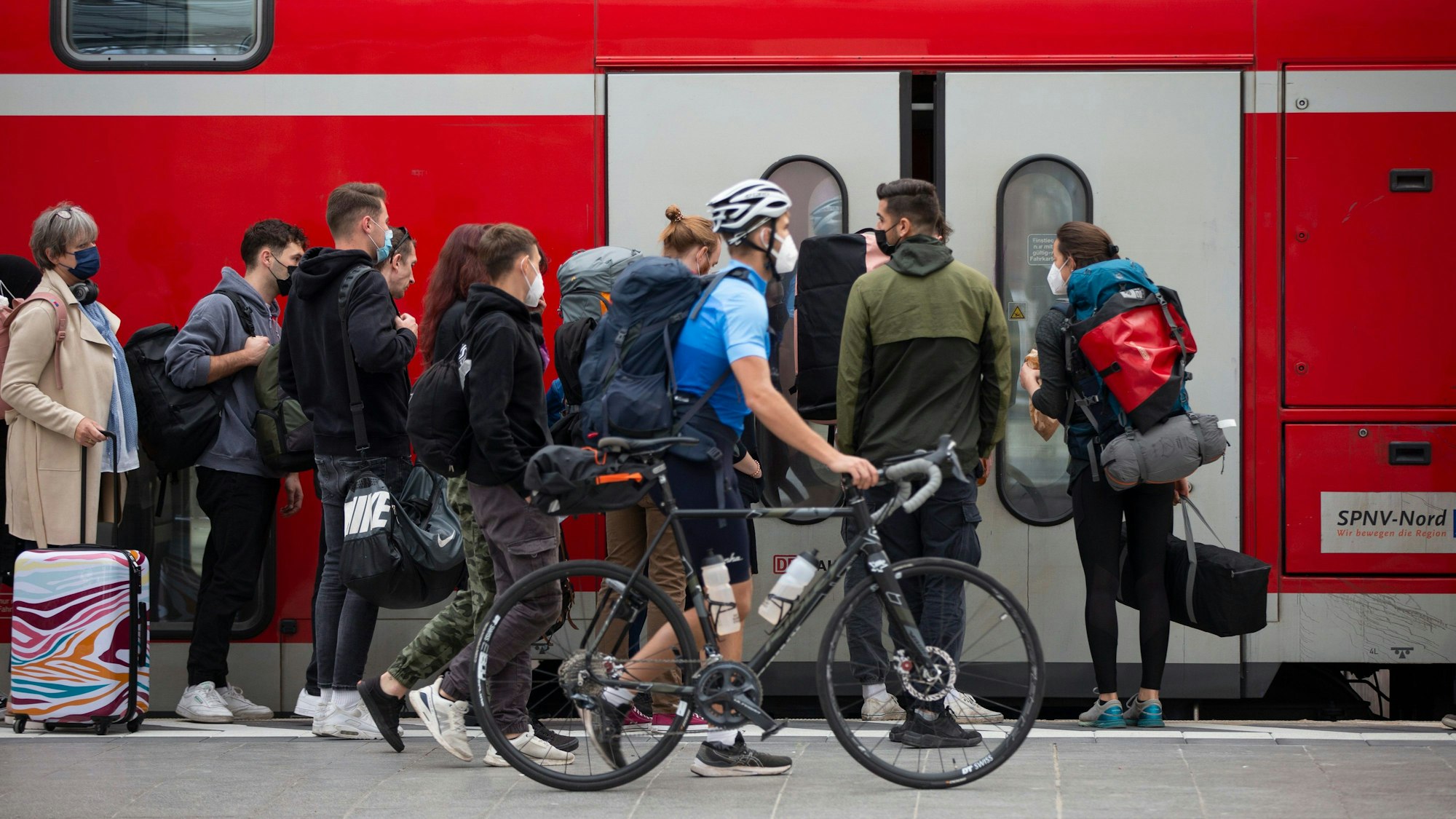 Fahrgäste steigen am Kölner Hauptbahnhof in einen Zug ein. (Archivbild)