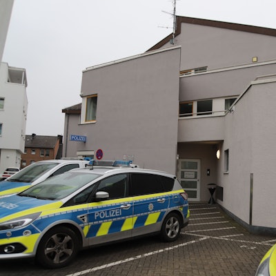 Die Polizeiwache in Troisdorf. Vor dem Gebäude stehen Wagen der Polizei.