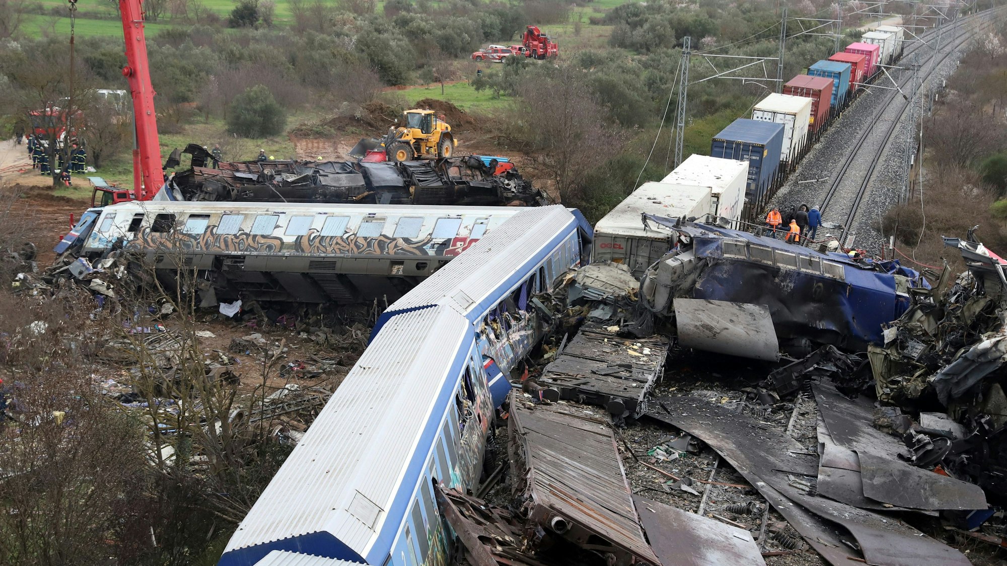 Zugtrümmer liegen auf und neben den Schienen. Die ersten Waggons beider Züge liegen im 90-Grad-Winkel abgeknickt neben der Strecke.