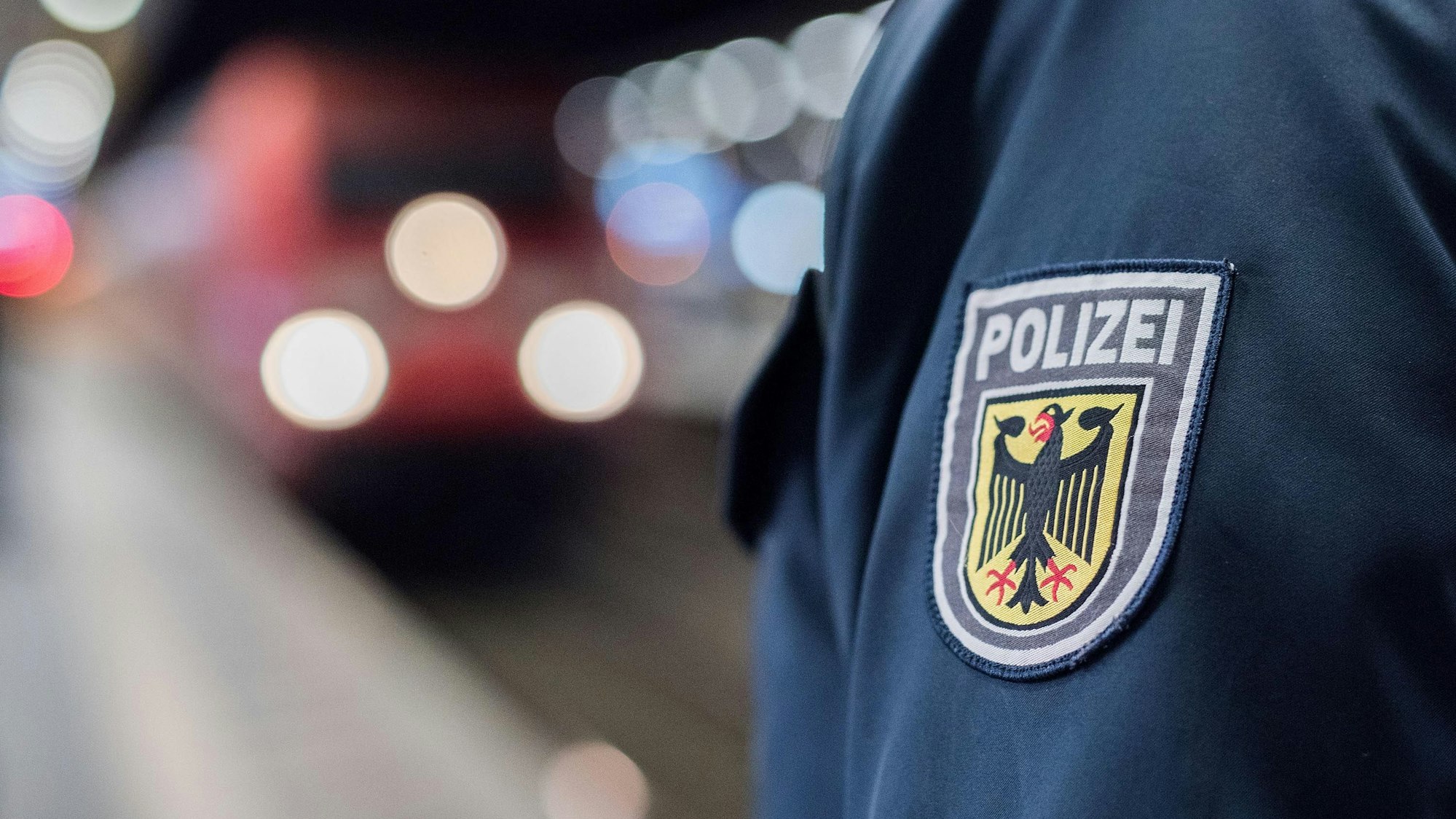 Ein Beamter der Bundespolizei steht am Gleis eines Bahnhofs.