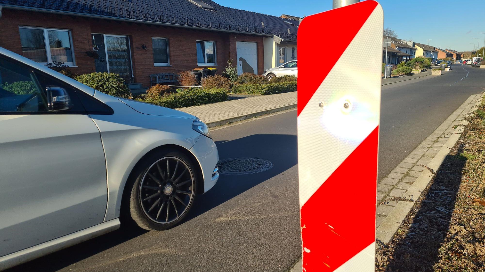 Ein weißes Auto fährt auf der Oleanderstraße.