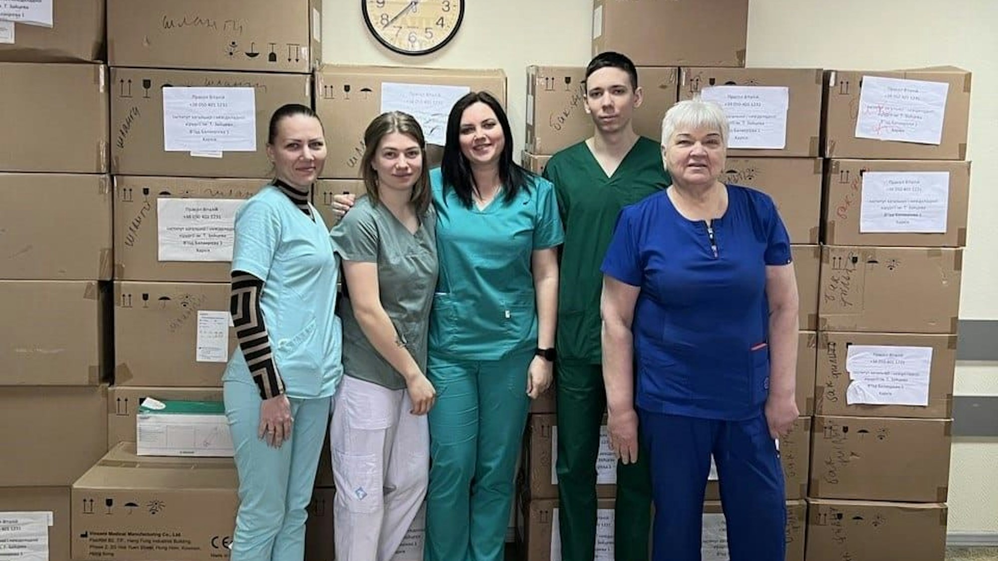 Die Mitarbeiterinnen und Mitarbeiter der Klinik in Charkiw freuen sich über die Ankunft neuer Hilfsmittel. Sie stehen vor zahlreichen Kartons.