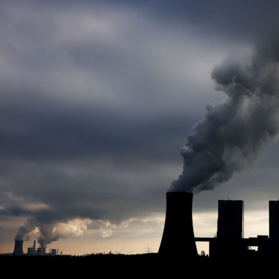 Dampf und Rauch steigt im Gegenlicht aus den Braunkohlekraftwerken Neurath II bei Grevenbroich und Niederaußem auf.