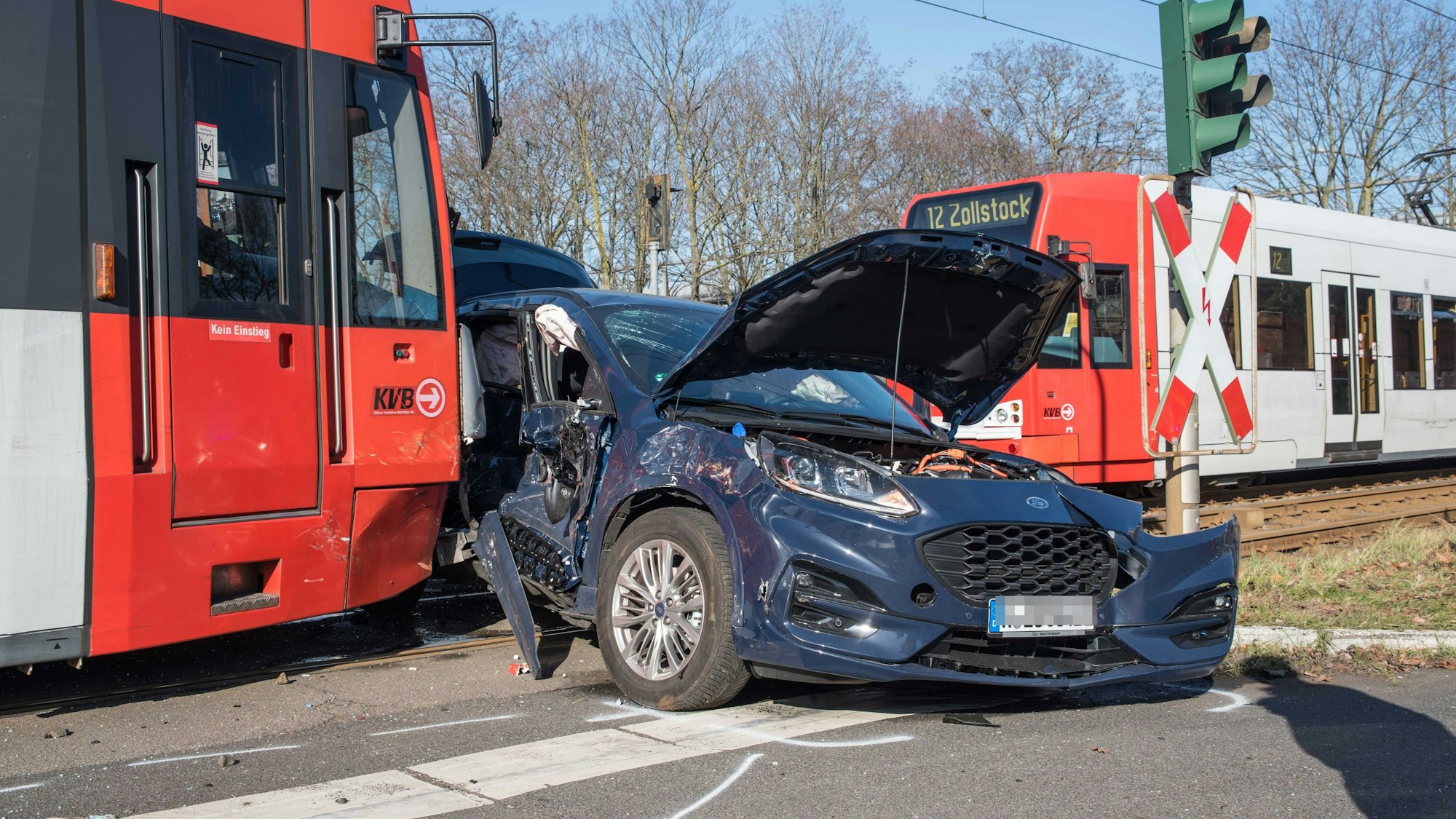 Eine Straßenbahn steht vor dem Wrack eines Autos.