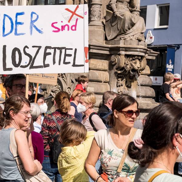 Eltern auf dem Alter Markt. Sie halten Schilder in der Hand, mit denen sie gegen die Verlosung von Schulplätzen demonstrieren.