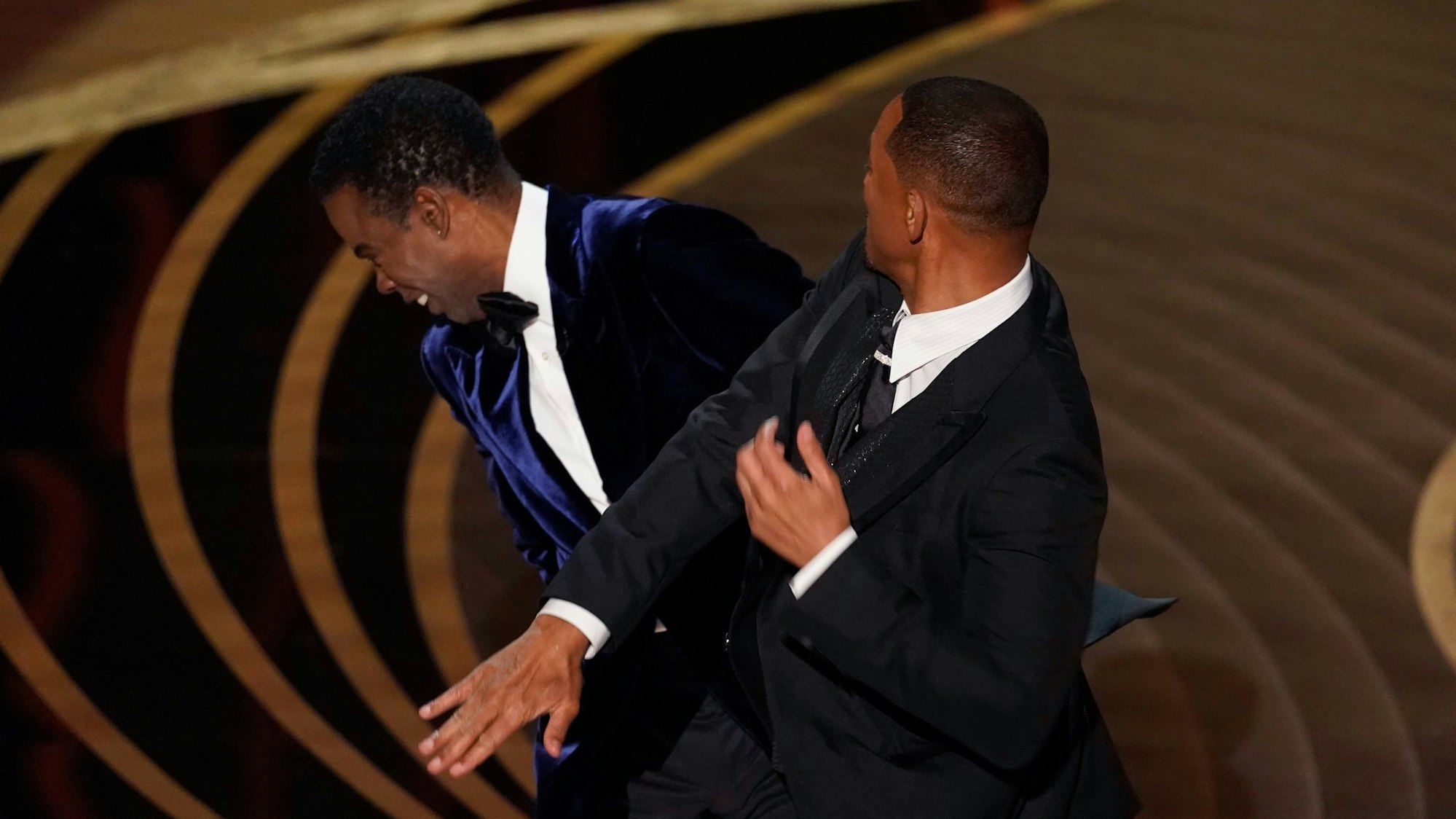 Will Smith (rechts) schlägt Moderator Chris Rock auf der Bühne, während der Oscar-Gala im vergangenen Jahr.