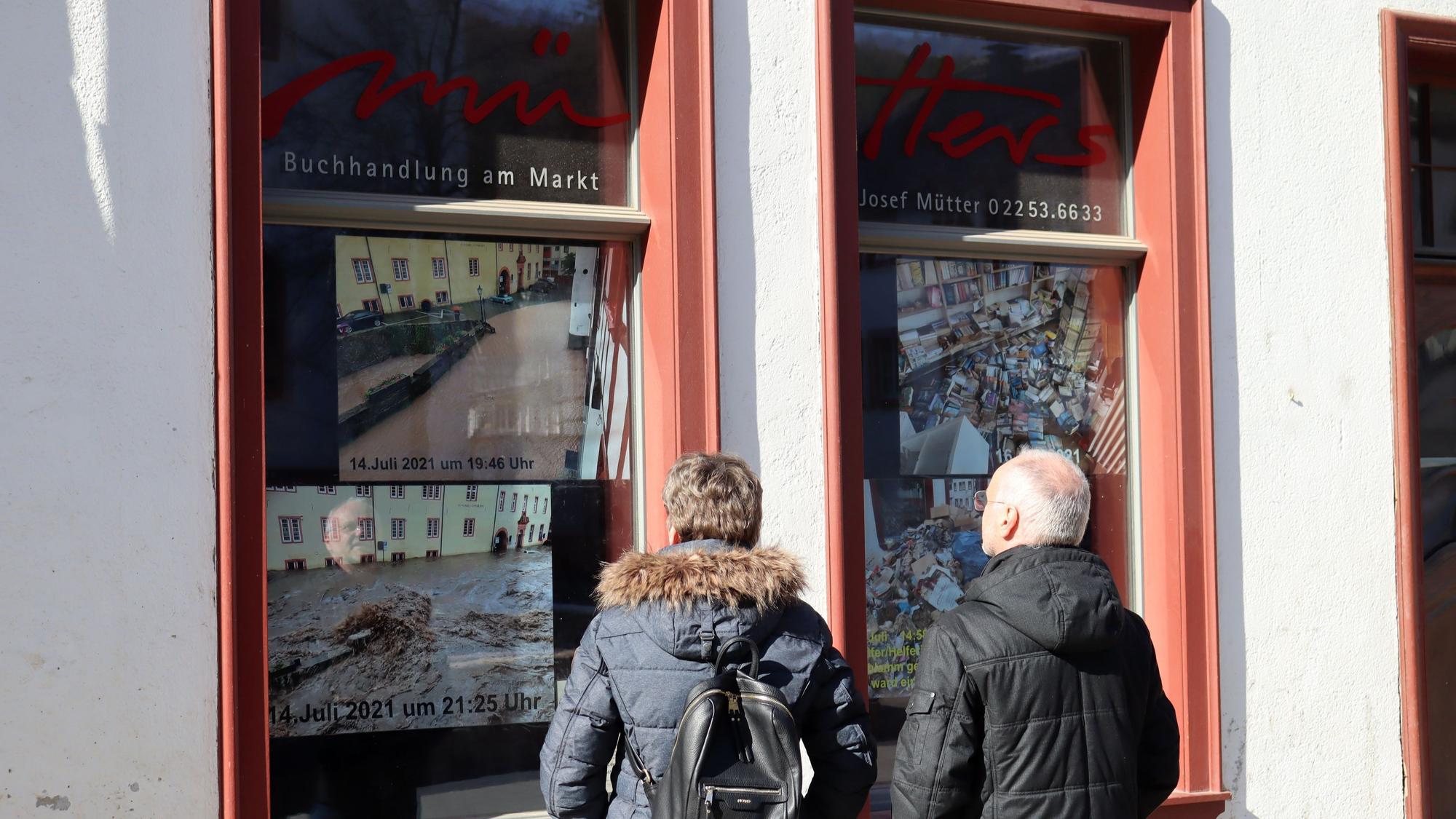 Blickfang: Passanten schauen sich die Fotos der Katastrophe an.