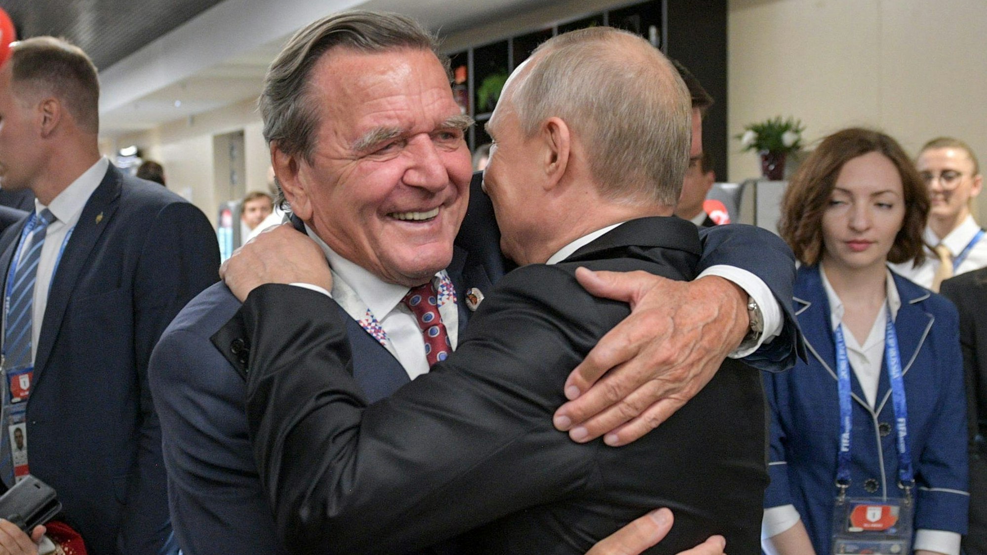14.06.2018, Russland, Moskau: Gerhard Schröder (SPD, l), ehemaliger Bundeskanzler, umarmt Wladimir Putin, Präsident von Russland, nach dem WM-Eröffnungsspiel Russland gegen Saudi-Arabien.