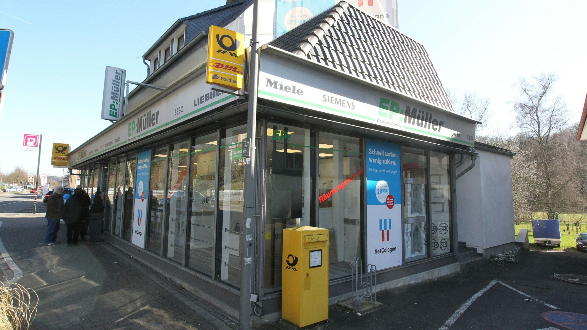 Menschen stehen vor einem Geschäft in Ruppichteroth.