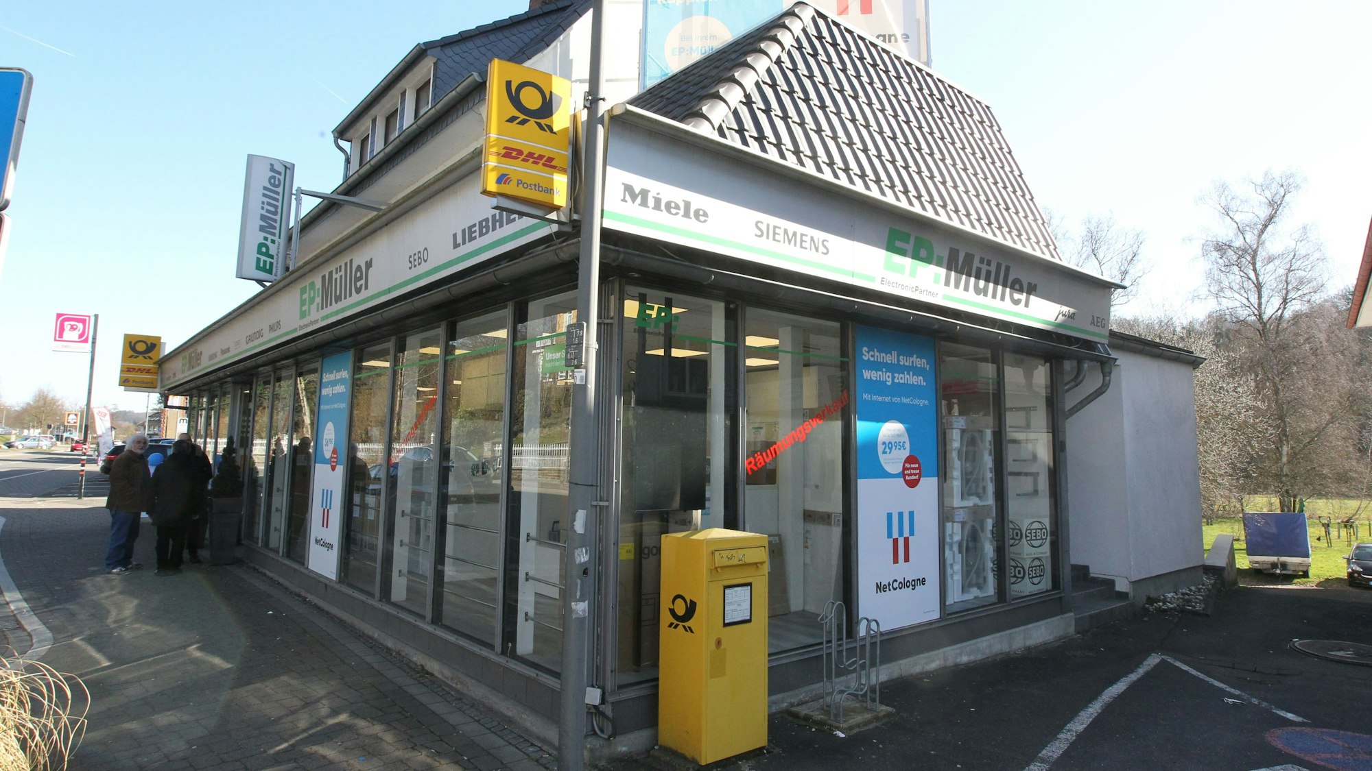 Menschen stehen vor einem Geschäft in Ruppichteroth.