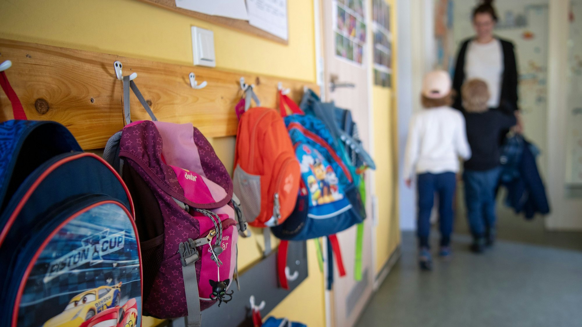 Kinderrucksäcke hängen im Eingangsbereich eines Kindergartens.