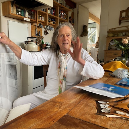 Mary Bauermeister sitzt an einem Tisch in ihrem Atelier.