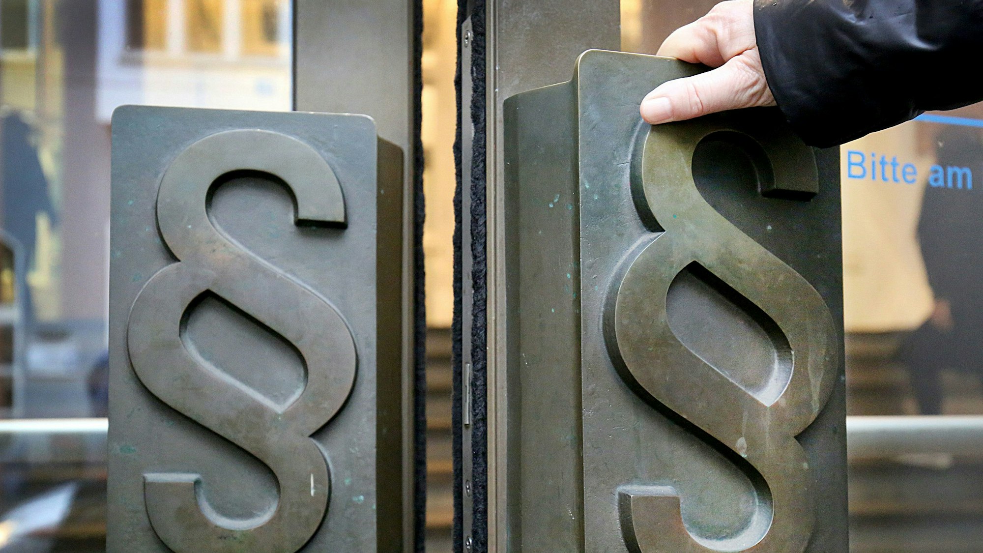 Paragrafen-Symbole sind an Türgriffen am Eingang zum Landgericht angebracht.