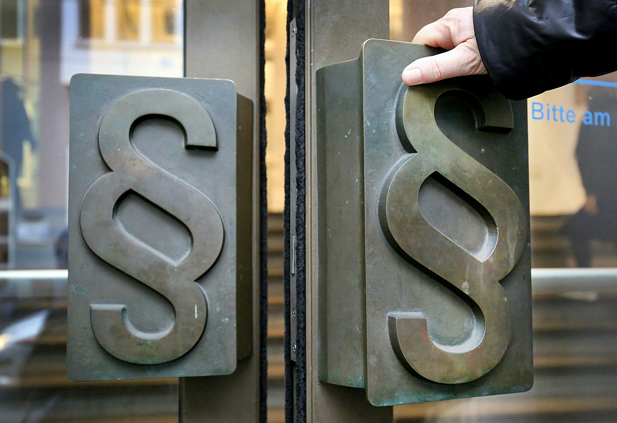 Paragrafen-Symbole sind an Türgriffen am Eingang zum Landgericht angebracht.