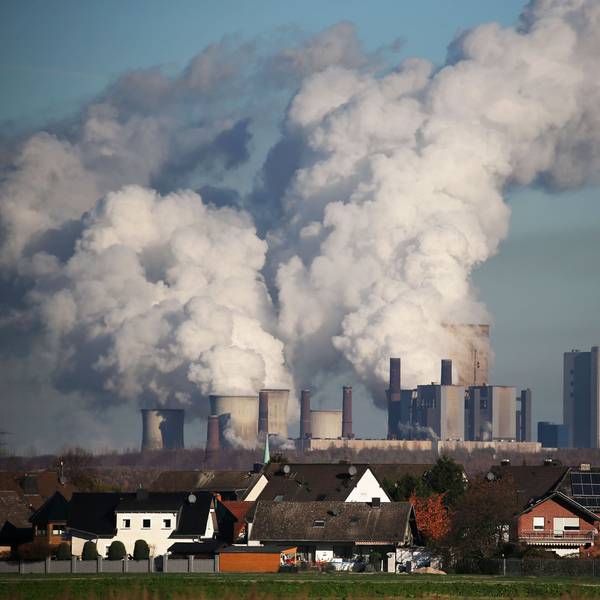 Hinter einer Wohnsiedlung bei Bergheim steigt Dampf aus dem Braunkohlekraftwerk Niederaußem des Energieversorgungskonzerns RWE.