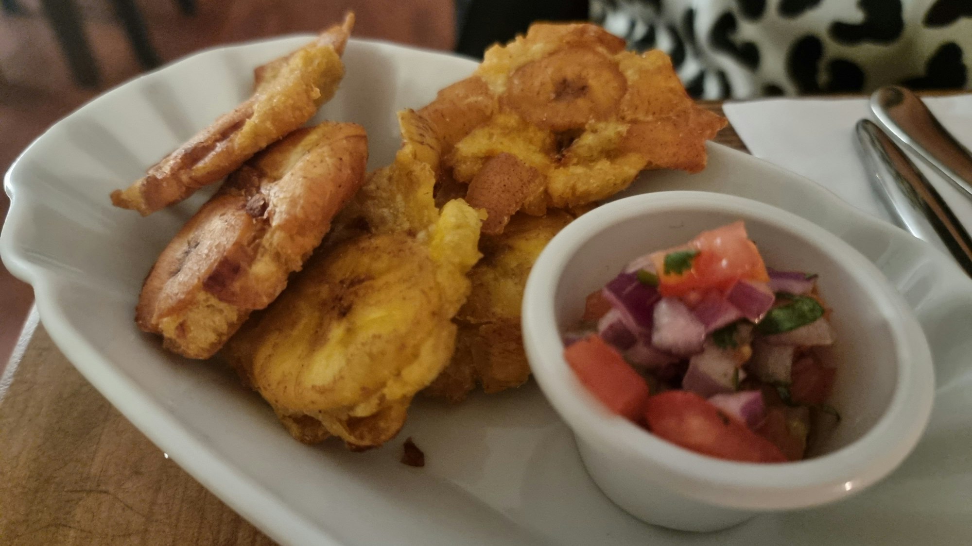 Ein Teller mit frittierten Kochbananen mit Salsa Criolla