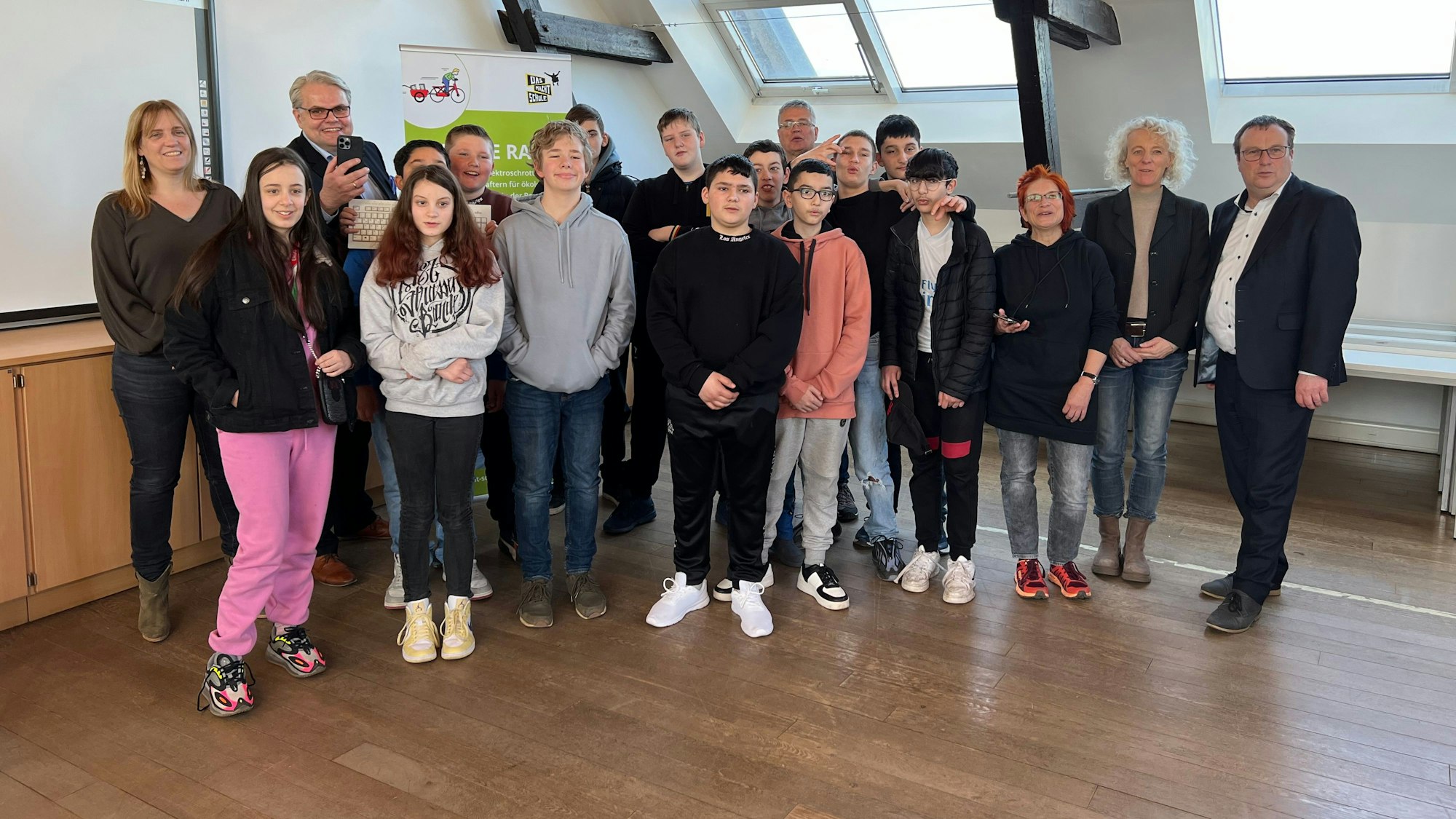 Viele Schüler stehen zusammen und schauen in die Kamera.