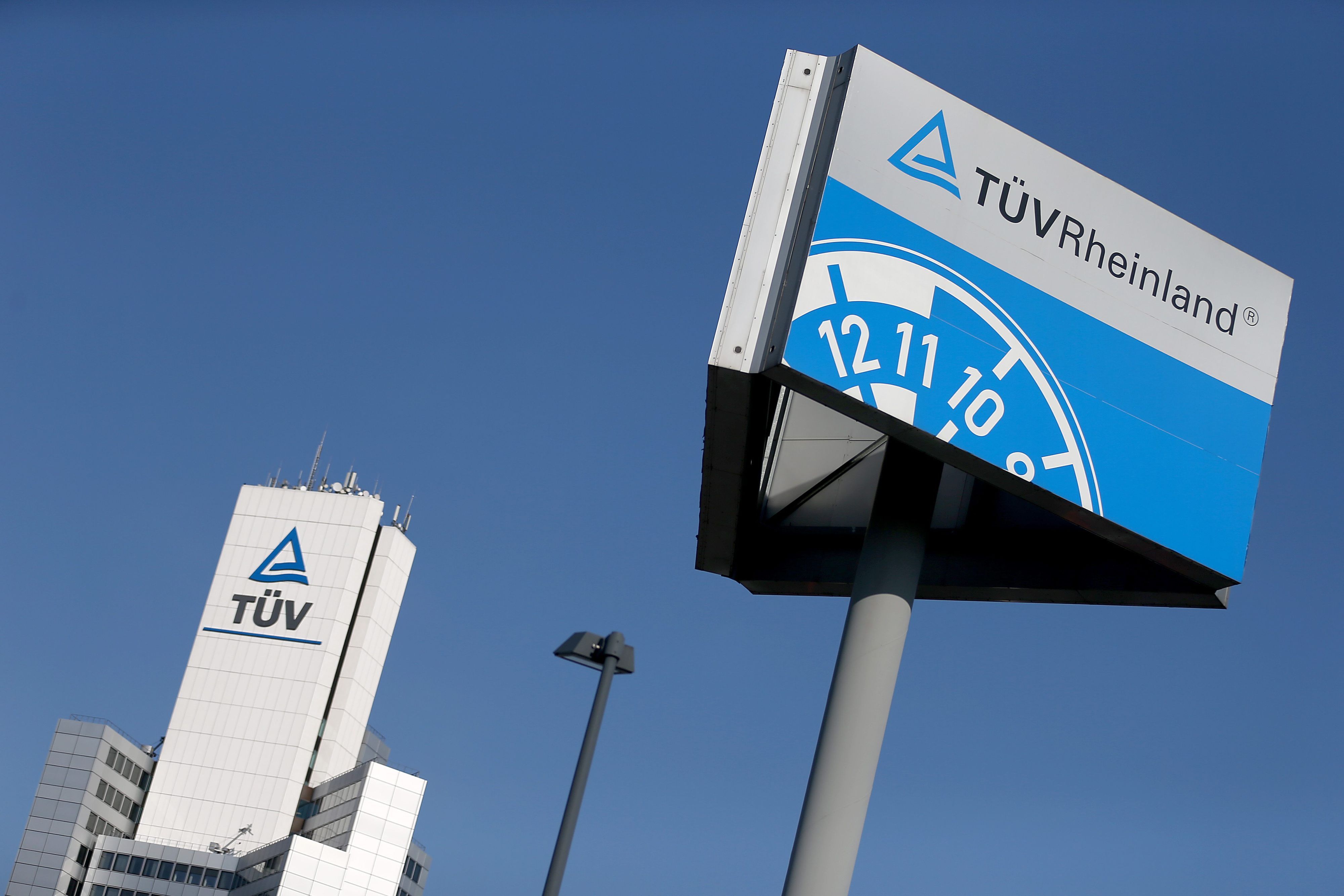 Der Himmel ist blau und es ist ein Hinweisschild des TÜV Rheinland zu sehen.