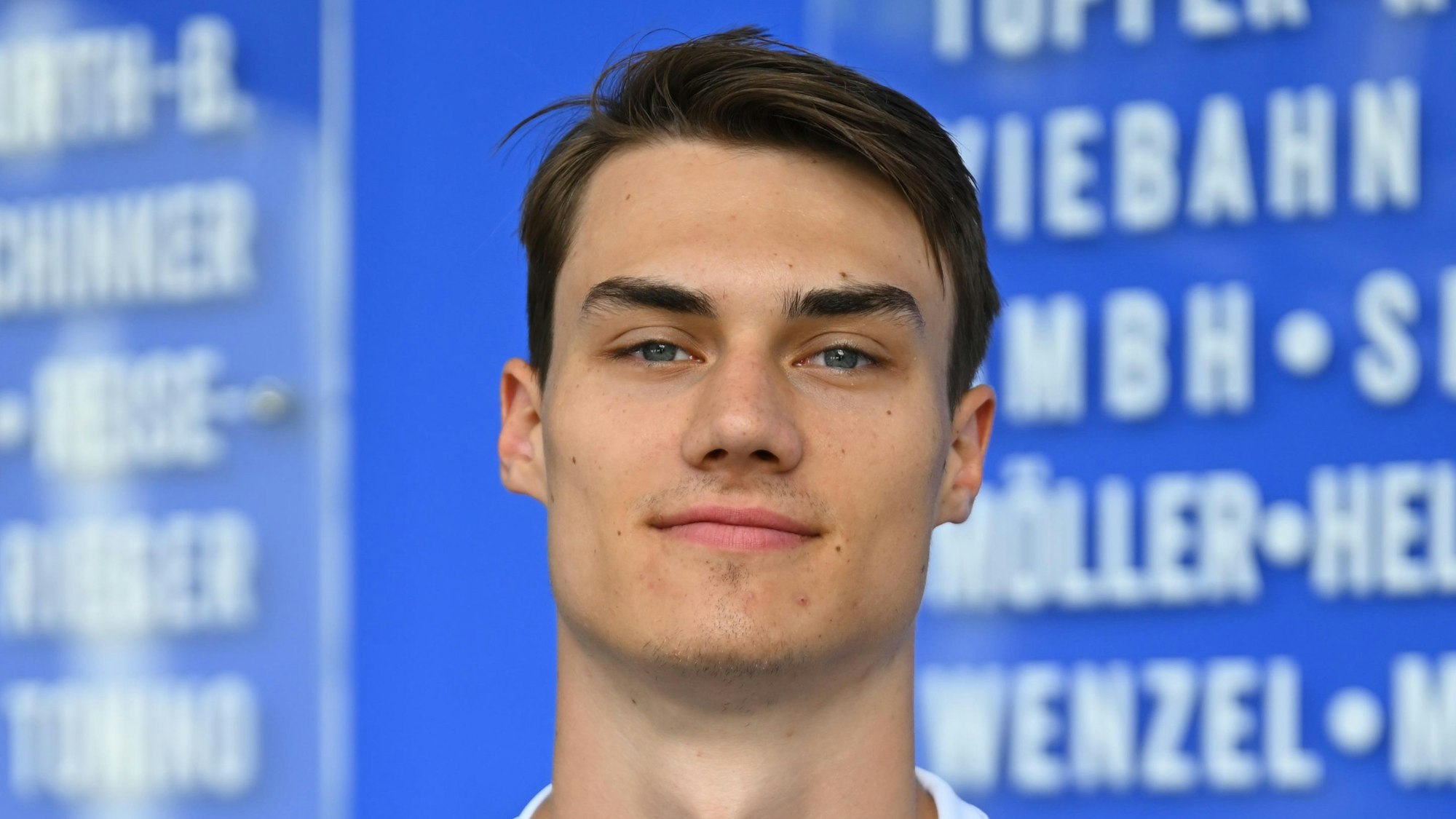 Der Handballer Miro Schluroff ist im Porträt zu sehen. Er trägt ein blau-weißes Trikot des Handballvereins VfL Gummersbach.