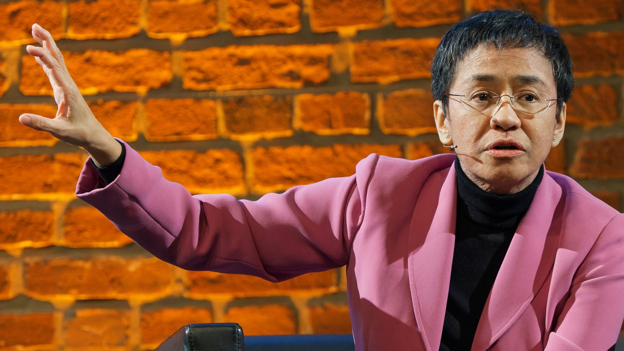 Die Friedensnobelpreisträgerin Maria Ressa in einem rosafarbenen Blazer und einem schwarzen Rollkragenpullover auf der Bühne der Balloni-Hallen