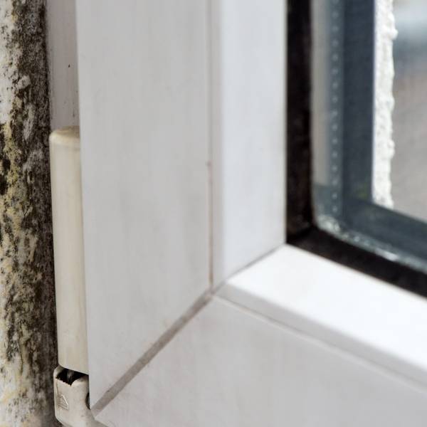 Schimmelflecken am Rand eines Fensters.