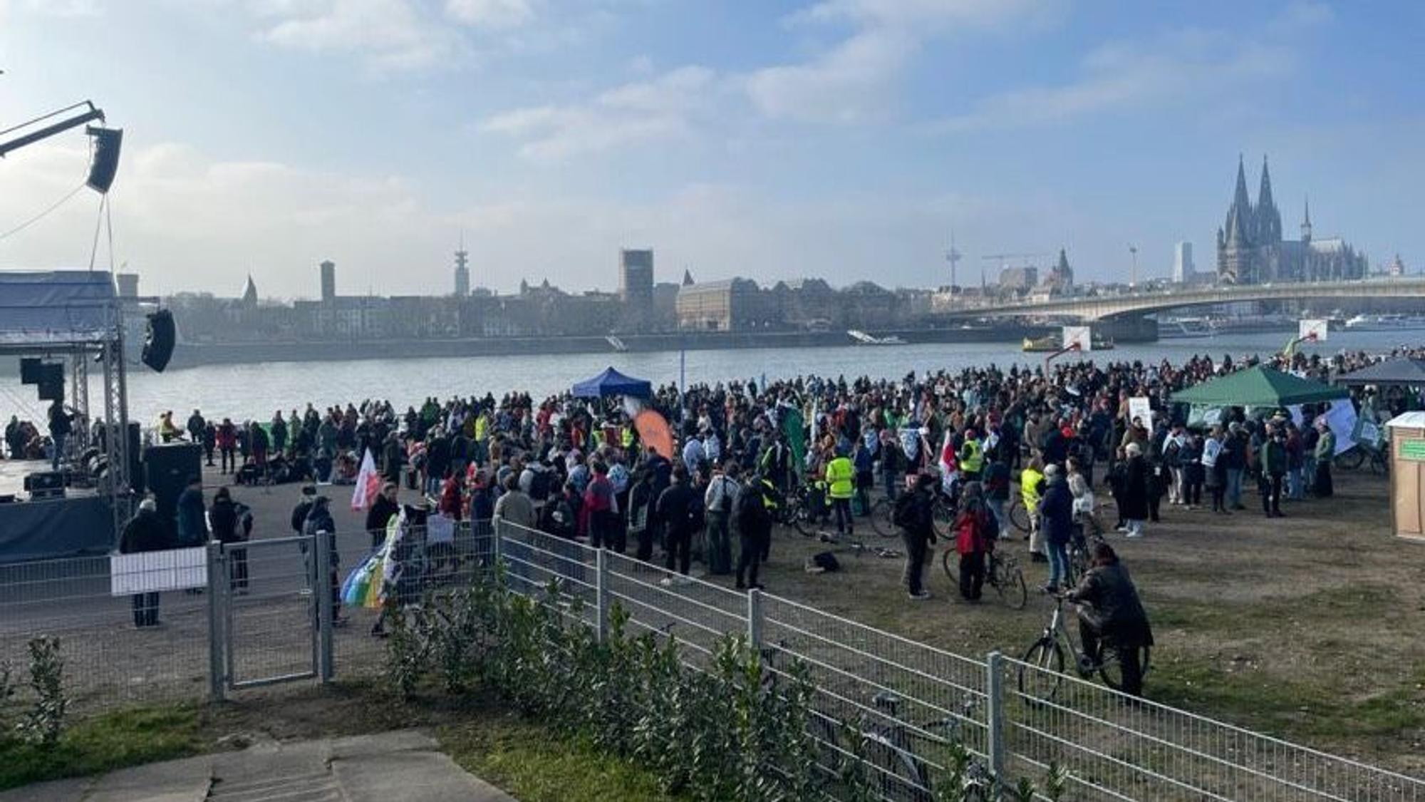Blick auf die Deutzer Werft, wo sich zahlreiche Menschen versammeln. Im Hintergrund sieht man den Rhein und den Dom.