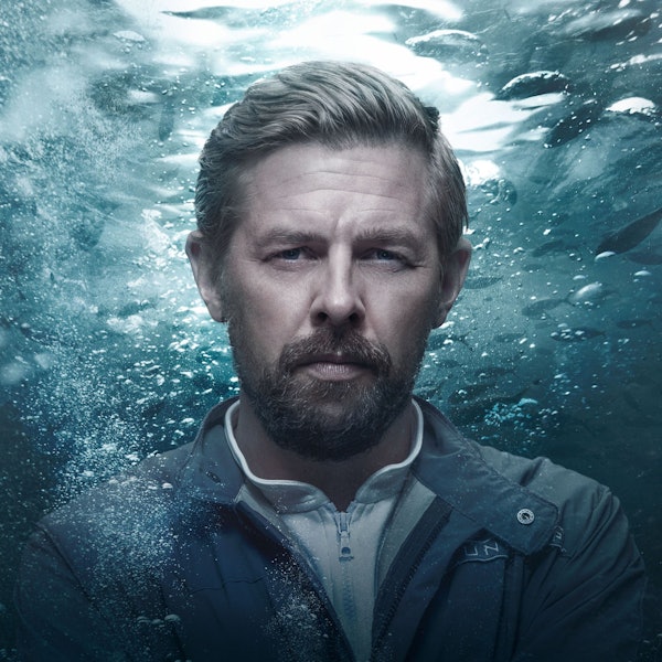 Klaas Heufer-Umlauf steht in seiner Rolle als Roscovitz vor einer Meeresoptik.