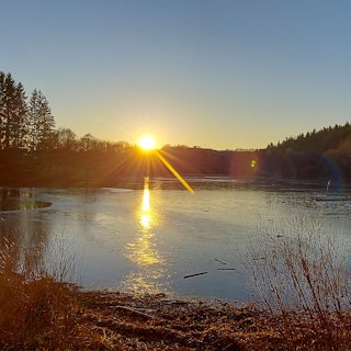 Vorstau des Kronenburger Sees bei Sonnenuntergang.