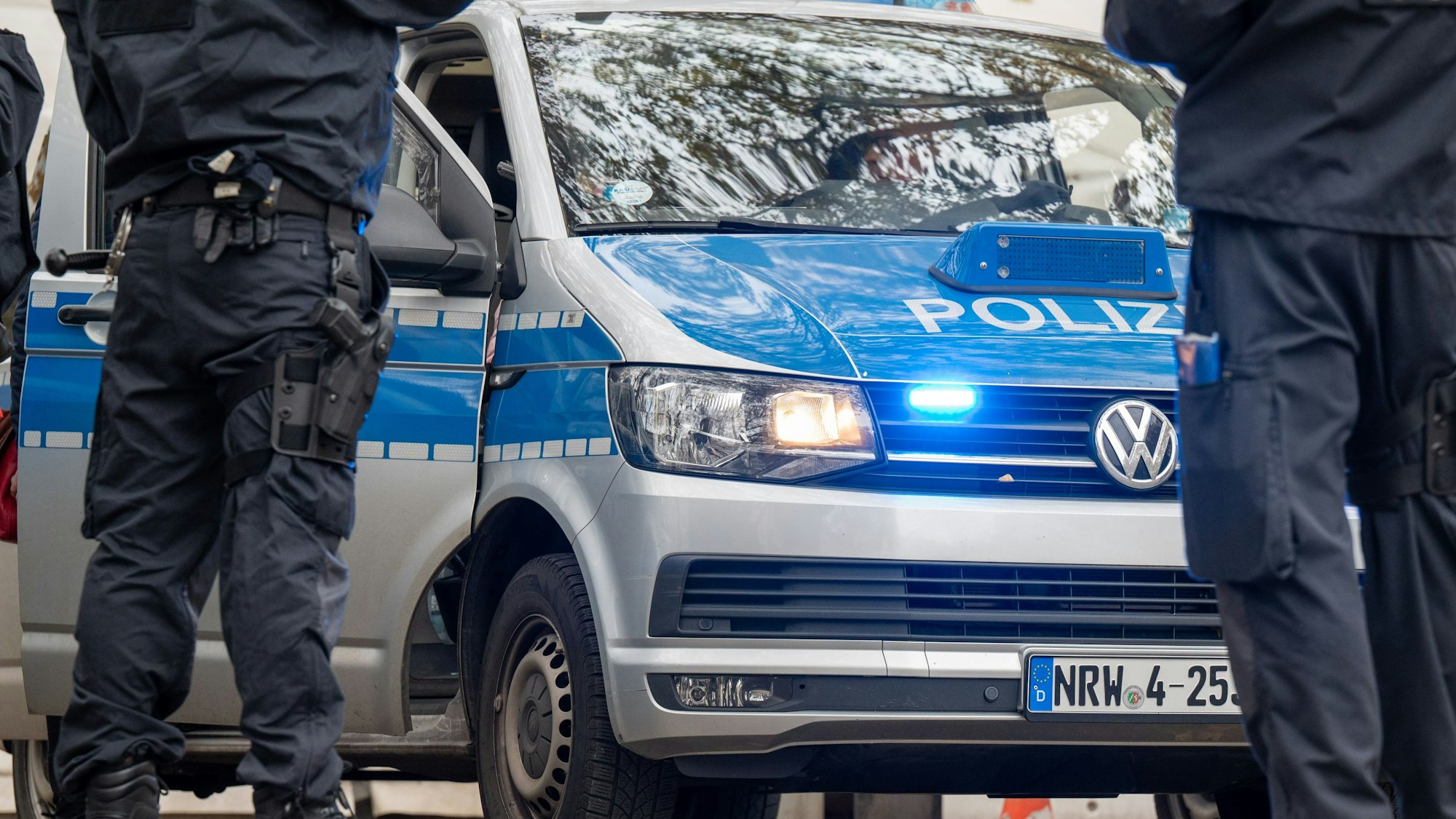 Polizisten und Einsatzfahrzeuge der Polizei. (Symbolbild)