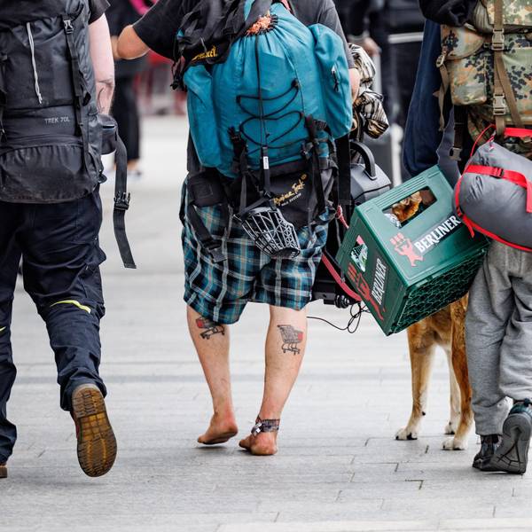 Eine Gruppe Punks schlendert mit Rucksäcken, umgeschnallten Schlafsäcken und einer Kiste Bier in der Hand durch die Fußgängerzone von Westerland auf Sylt.