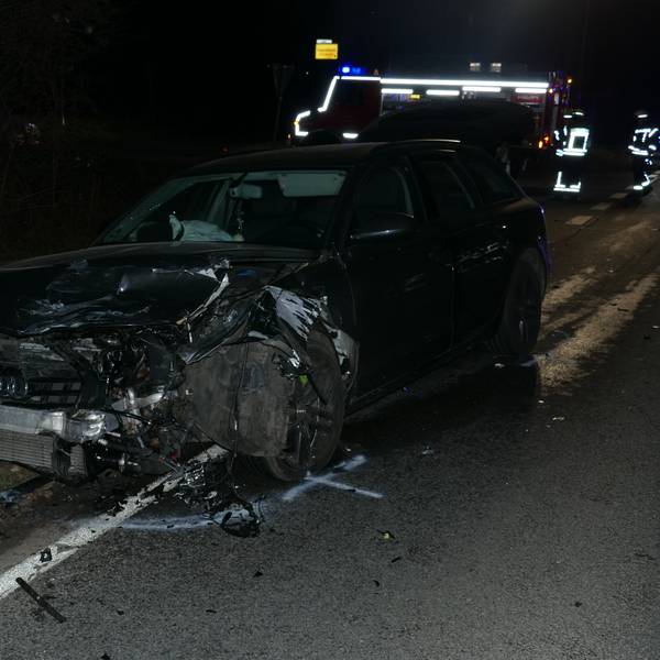 Ein Auto, das vom Unfall an der Vorderseite zerstört ist, steht am Straßenrand