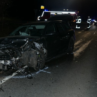 Ein Auto, das vom Unfall an der Vorderseite zerstört ist, steht am Straßenrand