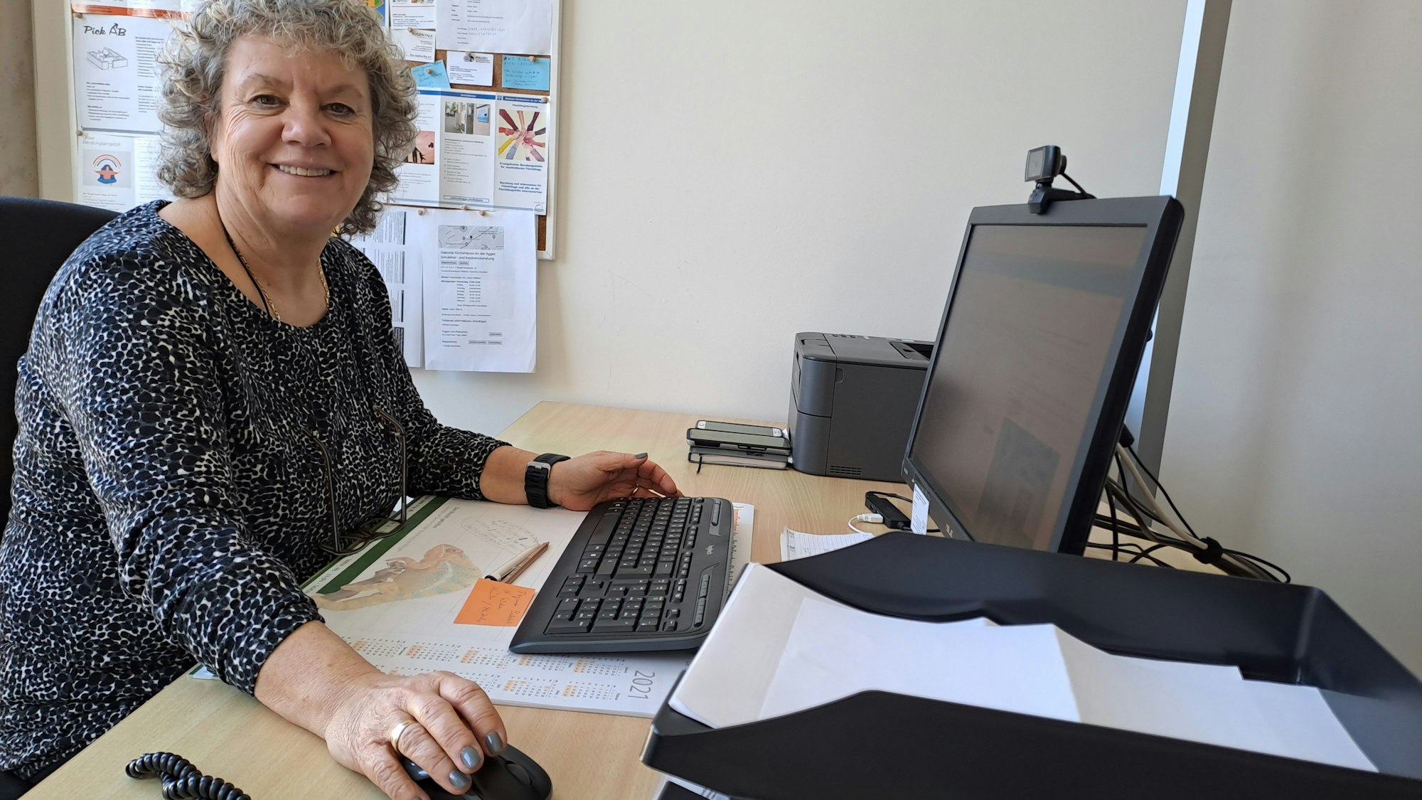 Case-Managerin Marion Hütten sitzt an ihrem Schreibtisch mit der Computermaus in der Hand.