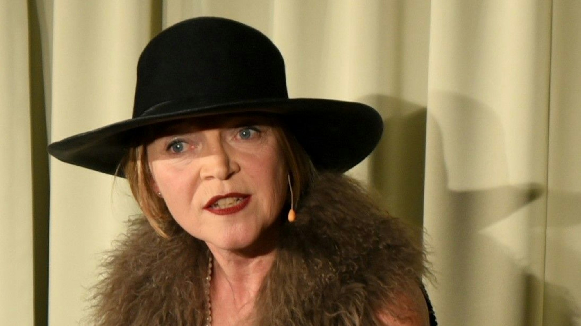 Jutta Seifert sitzt in Kostüm auf eine Stuhl.