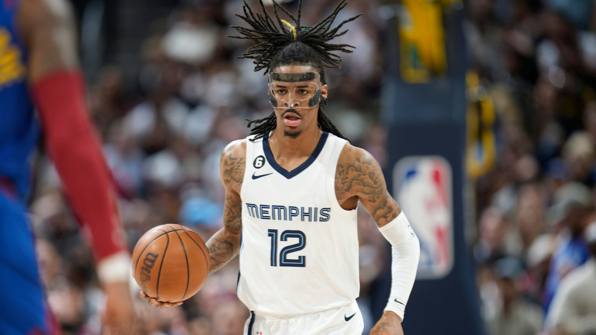 Ja Morant von den Memphis Grizzlies dribbelt mit einem Basketball in der Hand. Im Gesicht trägt er eine Schutzmaske.