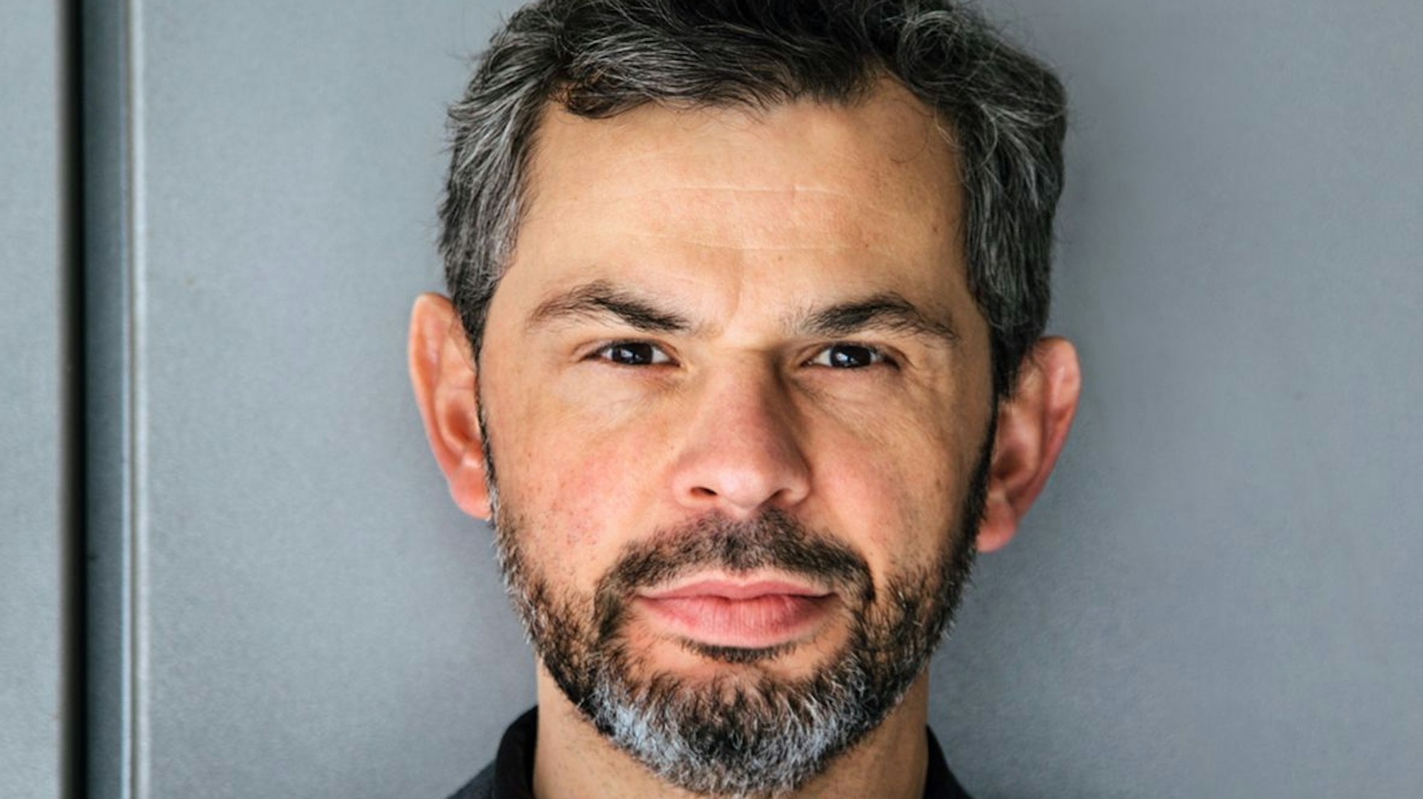 Thomas Dudek guckt in die Kamera. Er hat schwarz-graue Haare und einen schwarz-grauen Bart.