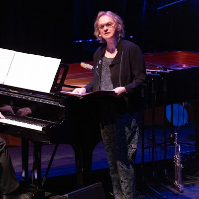 Der Musiker Marc-Aurel Floros sitzt am Flügel und Elke Heidenreich steht mit einer Mappe in der Hand daneben.